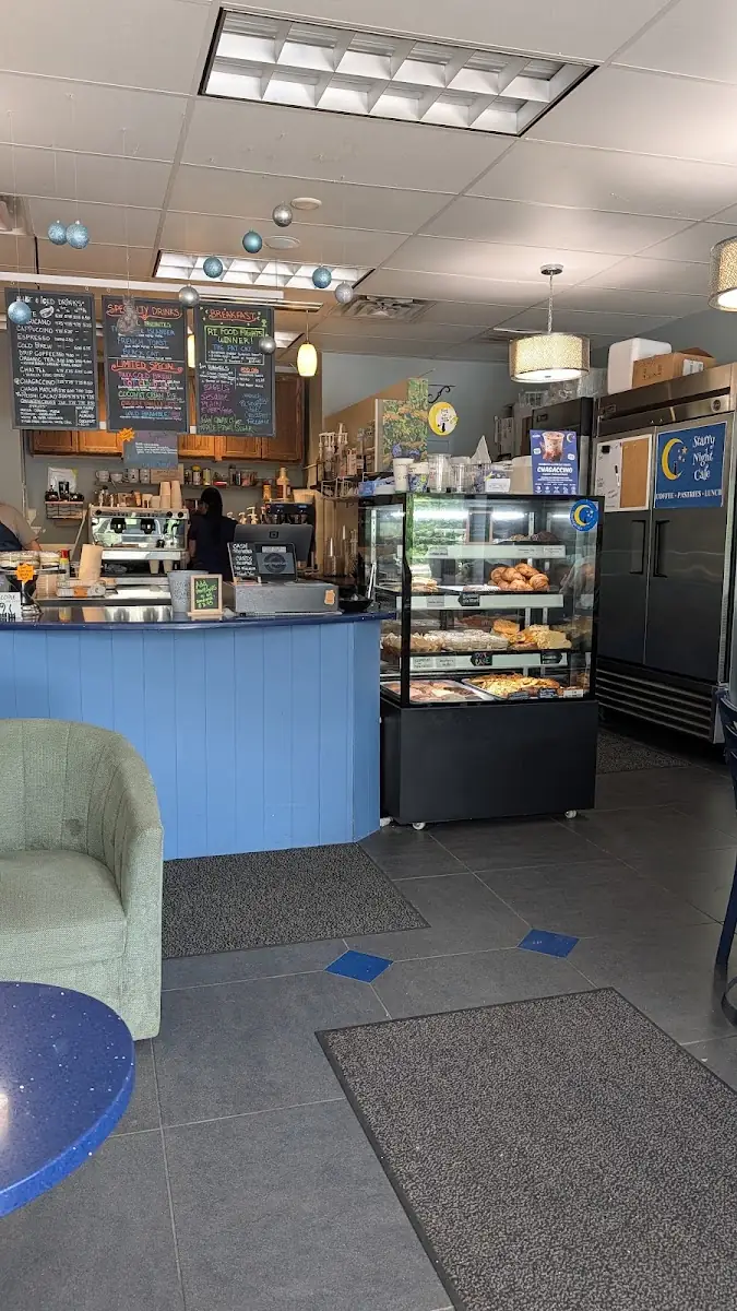 Inside Starry Night Cafe — blue counter, full pastry case and a cozy corner
